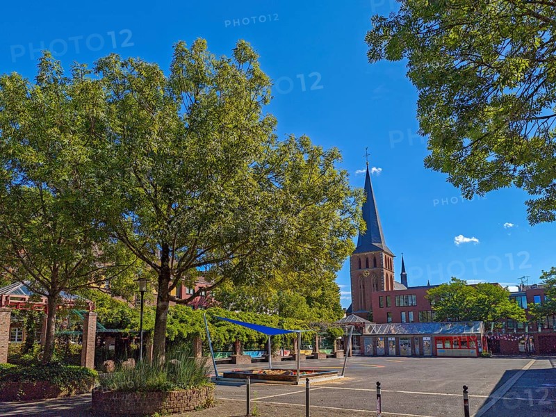 Old town with catholic church St. Margareta, brick building, architecture, square with sandpit, trees, blue sky, sunshine, religion, Brühl, North Rhine-Westphalia, Germany