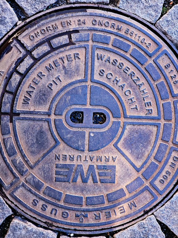 Cover of a water meter pit, water meter pit, city centre, street, round cast iron shape, standard, Brühl, North Rhine-Westphalia, Germany