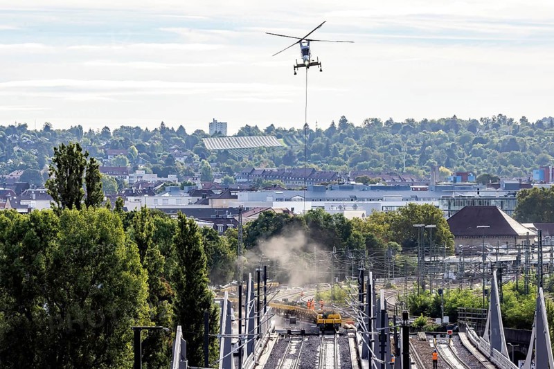 Track construction from the air. At Bad Cannstatt railway station, a transport helicopter transports 26 catenary masts to their destination. The masts, weighing up to 2.4 tonnes, were delivered by rail. The reason for this is to improve the infrastructure as part of the Stuttgart 21 project. Stuttgart, Baden-Württemberg, Germany