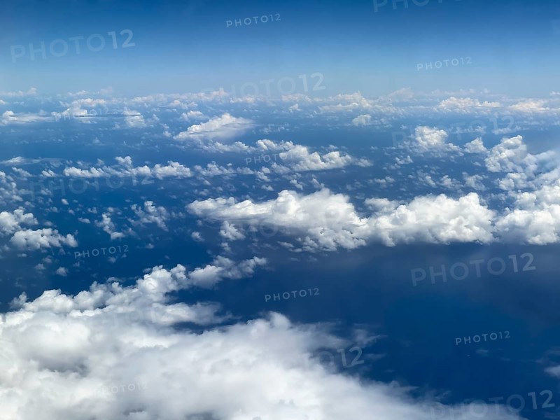 Aerial view from aeroplane at high altitude of white, bright cluster clouds Altocumulus, international