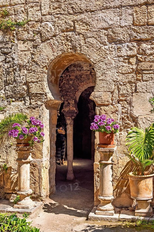 Flowers on pedestals at an opening into the Arab baths old building with oriental architecture, Palma de Mallorca, Mallorca, Spain
