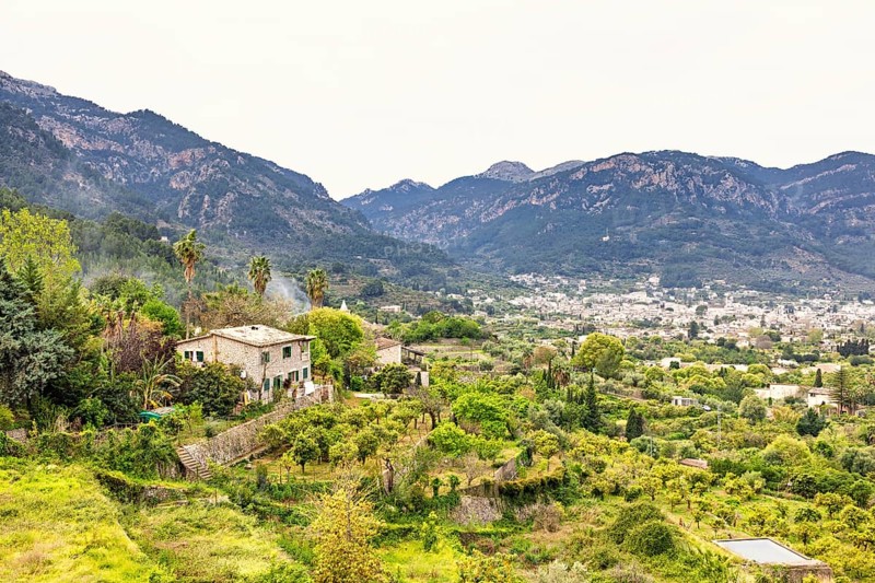 View at mountain village in a valley with lush green orchards and farms, Sóller, Mallorca, Spain
