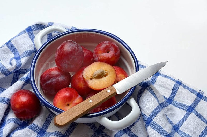Red plums in skin on cloth, Prunus domestica