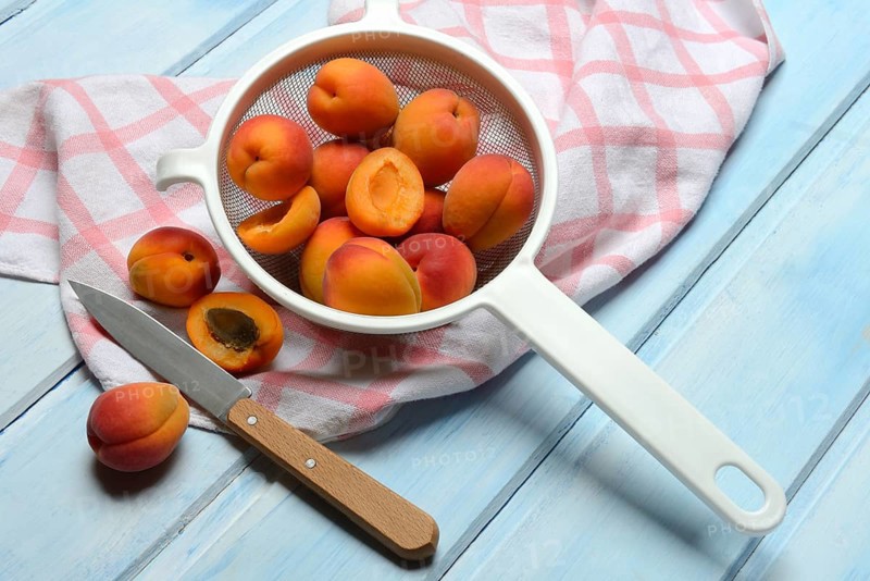 Apricots in colander, halved, Prunus armeniaca
