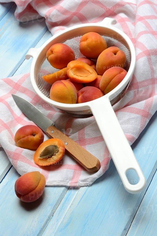 Apricots in colander, halved, Prunus armeniaca