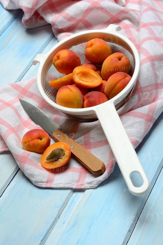 Apricots in colander, halved, Prunus armeniaca