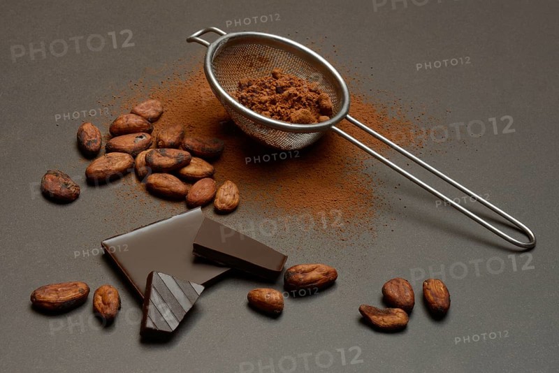Kitchen sieve with cocoa powder and chocolate, cocoa and cocoa beans