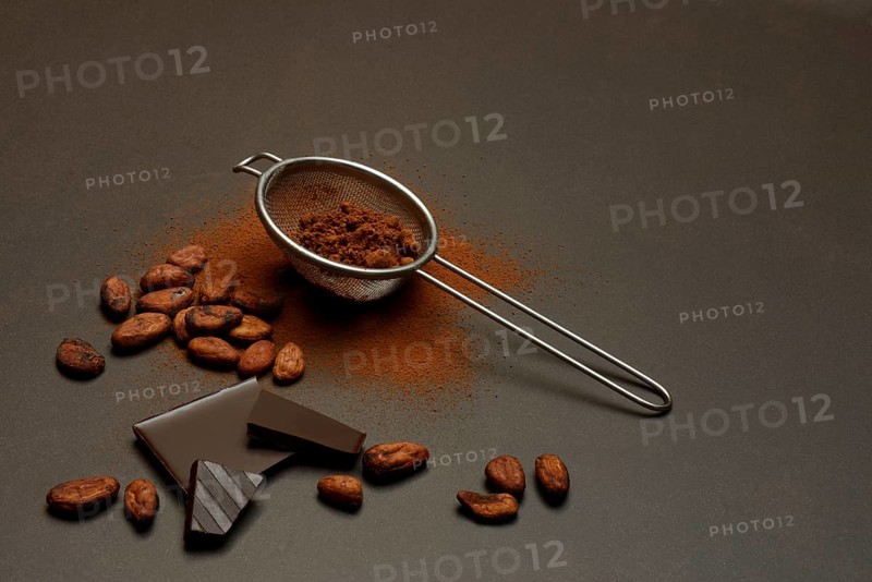 Kitchen sieve with cocoa powder and chocolate, cocoa and cocoa beans