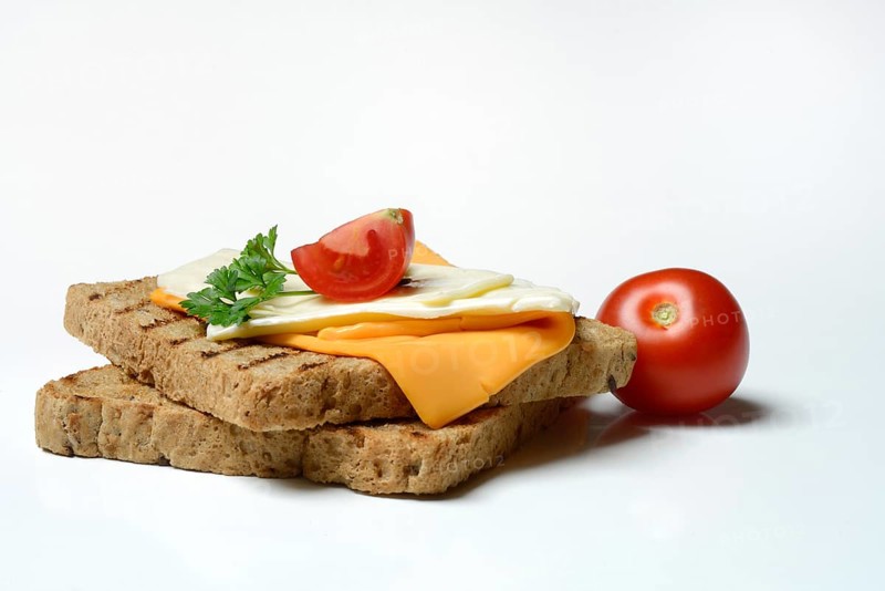 Processed cheese, slices of processed cheese on toast and tomato