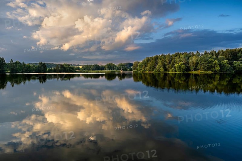 The Postfelden reservoir in the evening at the golden hour. Glowing clouds are reflected in the calm water. Höllbachtal, Postfelden, Rettenbach, Upper Palatinate, Bavaria, Germany