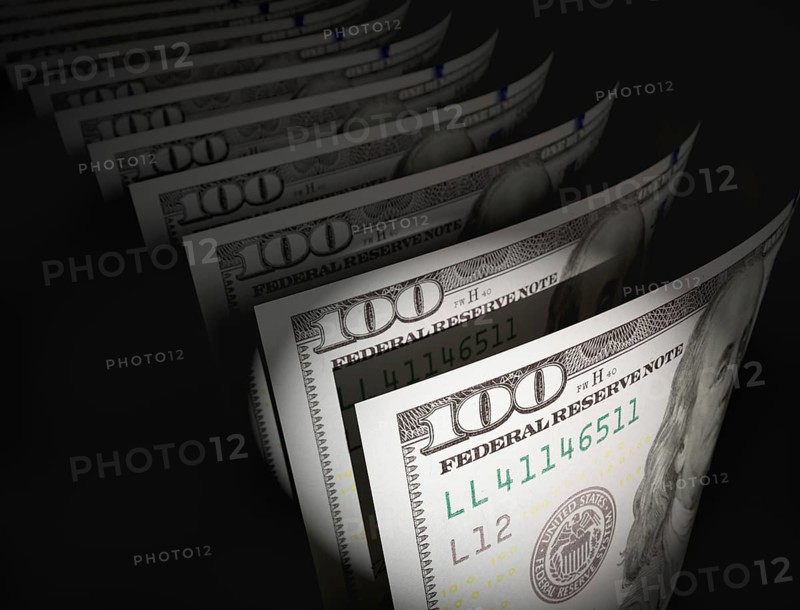 Spot lit abstract close-up angle of U.S. 100 dollar bills isolated on a black background