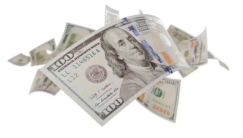 Randomly falling U.S. 100 dollar bills isolated on a white background