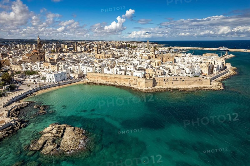 Old town of Monopoli with the cathedral, city walls and Cala Porta Vecchia beach seen from above, Apulia, Italy