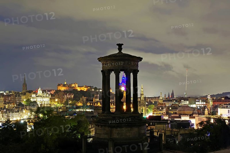 Night scene of Edinburgh with illuminated buildings and a historical monument in the foreground, Old Town, Calton Hill, Edinburgh, Scotland, United Kingdom