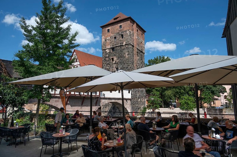 Historic water tower built around 1325, in front a café on the Pegnitz, Nuremberg, Middle Franconia, Bavaria, Germany