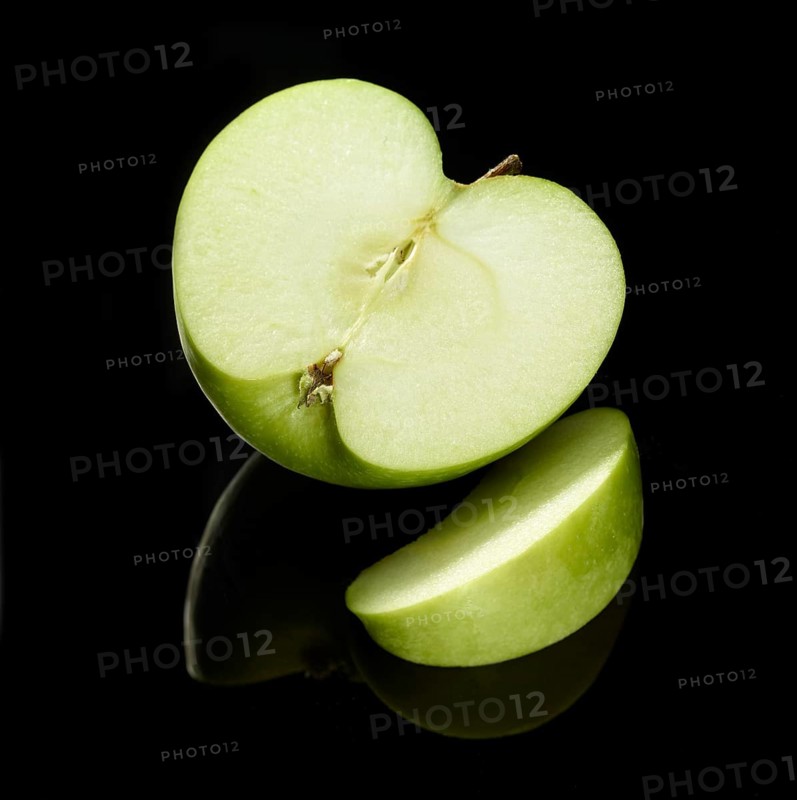 Apple half and apple slice (Malus pumila) in front of a black background