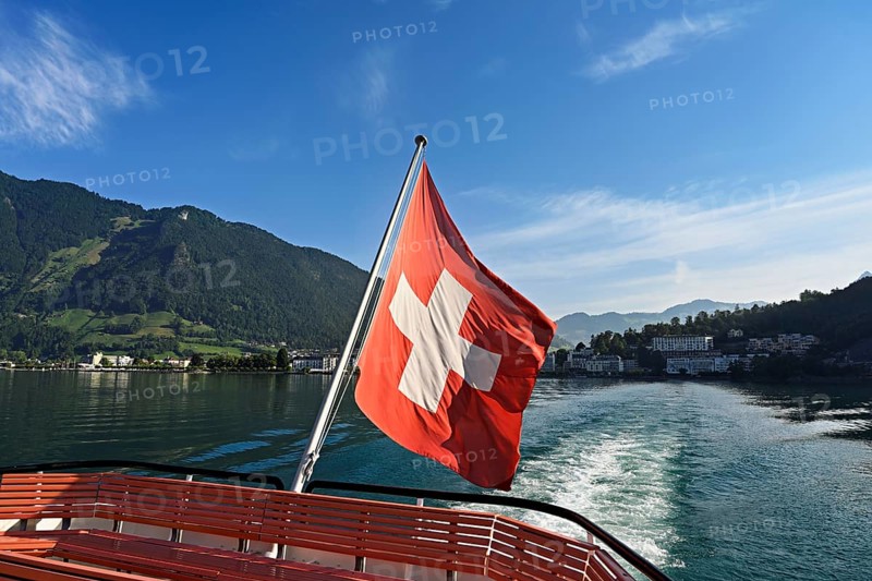 Swiss flag in the stern of the motor ship Brunnen in motion, Lake Lucerne, Brunnen, Canton, Schwyz, Switzerland