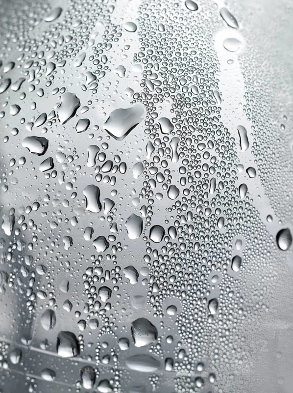 Drops of water on plastic bottle, neutrally illuminated, detailed view
