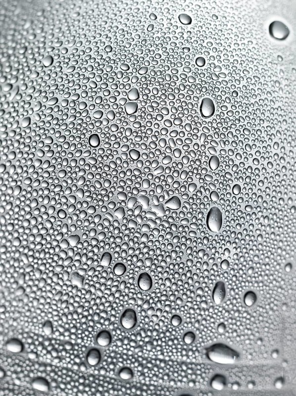 Drops of water on plastic bottle, neutrally illuminated, detailed view