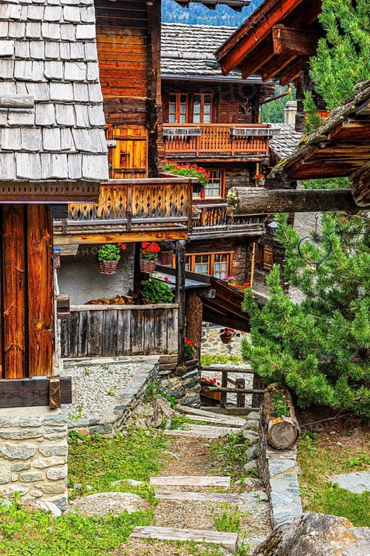 Winding wooden houses with flower-decorated balconies in the historic centre of Grimentz, Val d'Anniviers, Valais Alps, Canton Valais, Switzerland
