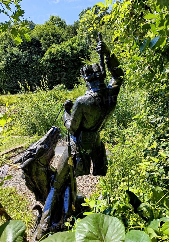 Statue of the swamp scene Pulling yourself out of the swamp by your own bootstraps in the Münchhausen town of Bodenwerder, Weserbergland, Lower Saxony, Germany