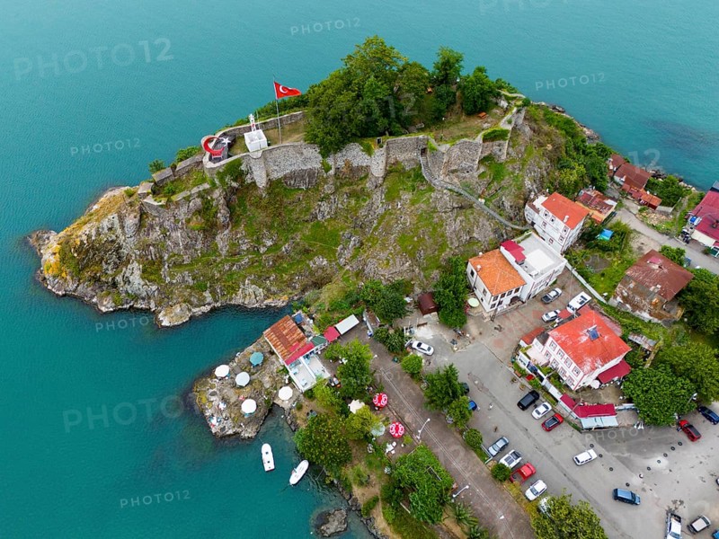 Aerial view of a castle by the sea with Turkish flag and surrounding buildings, aerial view, fortress, castle, Tirebolu, Giresun Province, Black Sea, Turkey