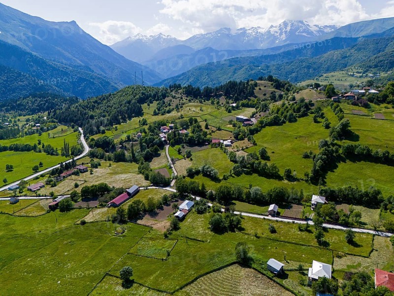 Hilly landscape with small settlements and green fields surrounded by mountains, aerial view, landscape near Iskari, Mingrelia and Upper Svaneti, Samegrelo-Zemo Svaneti, Svaneti, High or Greater Caucasus, Georgia