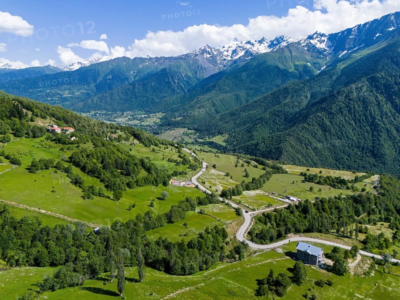 Panoramic view of a valley with roads and forests, surrounded by mountains under a clear sky, aerial view, landscape near Iskari, Mingrelia and Upper Svaneti, Samegrelo-Zemo Svaneti, Svaneti, High or Greater Caucasus, Georgia