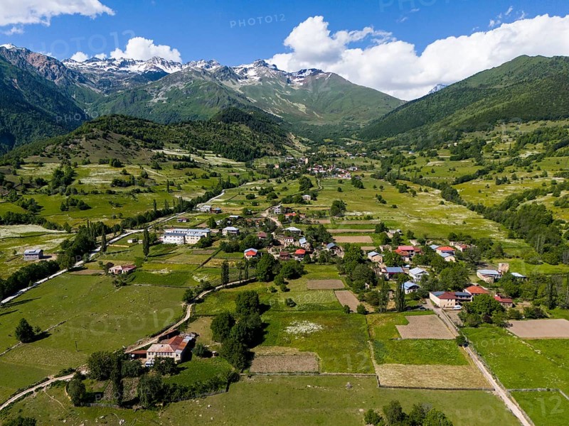 Vast landscape with villages and fields under a blue sky, framed by mountains, aerial view, landscape near Iskari, Mingrelia and Upper Svaneti, Samegrelo-Zemo Svaneti, Svaneti, High or Greater Caucasus, Georgia