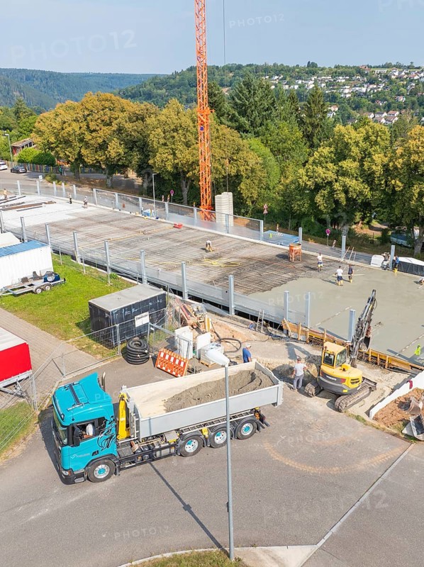 Truck and crane on an active construction site in a green, urban environment, car park construction, Calw, Germany