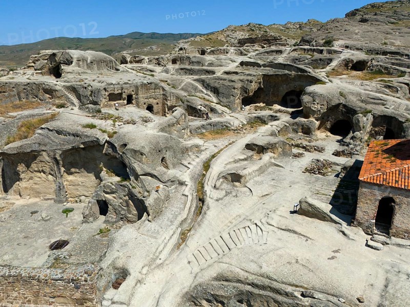 Ancient cave town with weathered sandstone structures and old paths under a blue sky, aerial view, cave town Uplistsikhe, Uplistsikhe, Inner Kartlia region, Shida Kartli, Georgia