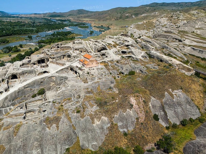Historic cave town Uplistsikhe with impressive ruins in a green river landscape, aerial view, cave town Uplistsikhe, Uplistsikhe, river Kura or Mtkvari, Inner Kartlia region, Shida Kartli, Georgia
