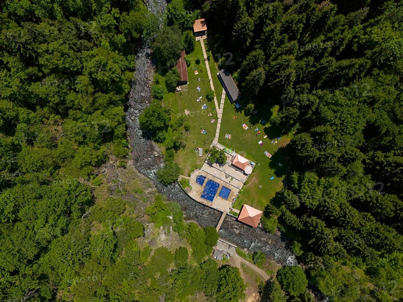 Aerial view of a forest area with swimming pool and river, surrounded by dense trees and buildings, aerial view, outdoor swimming pool, sulphur springs of Borjomi, Borjomi, Samtskhe-Javakheti region, Kura river, Lesser Caucasus, Georgia