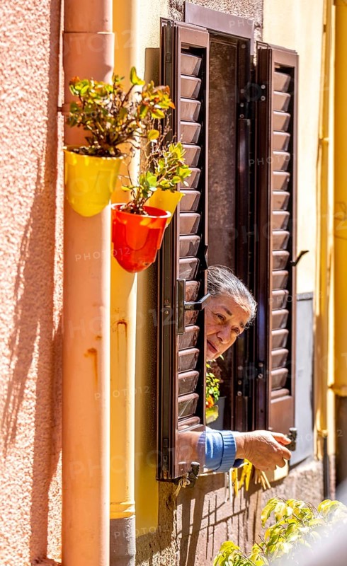Sardinia, inhabitant looking out of a window, Bosa, Europe, Province of Oristano, Italy, everyday life, old, architecture, authenticity, observation, view, village, inhabitant, window, shutters, woman, building, Italian, landscape, lifestyle, perspective, travel, sightseeing, city, city view, stone, tourism, urban, residential building, historical, cultural, Mediterranean, curious, traditional, female