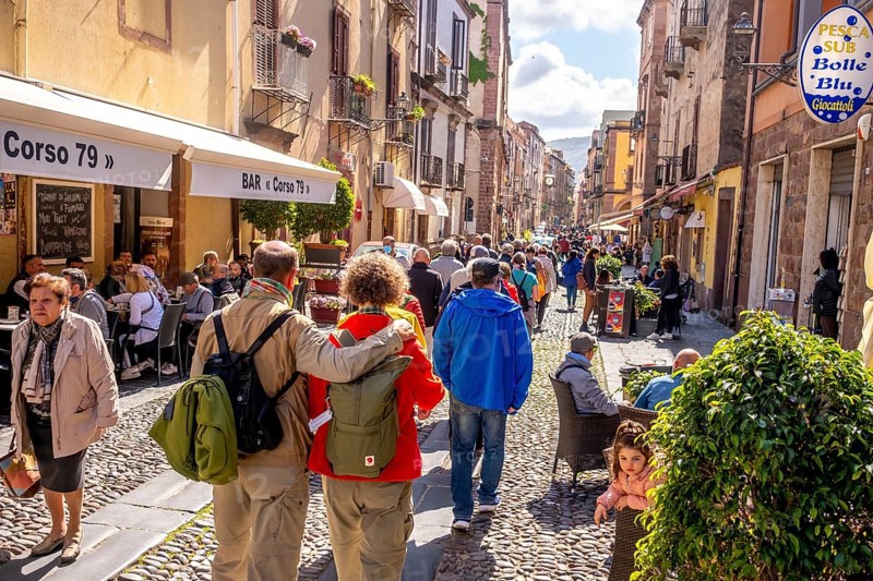 Sardinia, tourists in a pedestrian zone, stroll of tourists on a shopping street, Bosa, Europe, Province of Oristano, Italy, excursion, stroll, shopping street, relaxation, exploration, adult, strolling, leisure, leisure wear, pedestrian zone, building, shops, group, shops, people, Mediterranean, cobblestones, travel, travelling, shop window, shopping, sightseeing, summer, city, streets, daylight, tourism, tourists, urban, historical architecture, Italian, cultural, Mediterranean, sunny