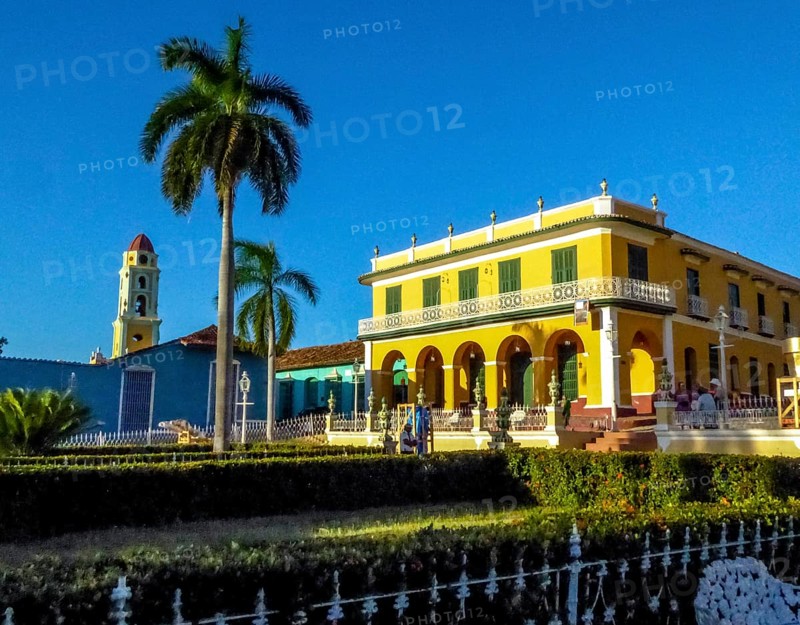 Centre of Trinidad Palacio Brunet, yellow palace with blue sky and the church Convento de San Francisco de Asis, Cuba