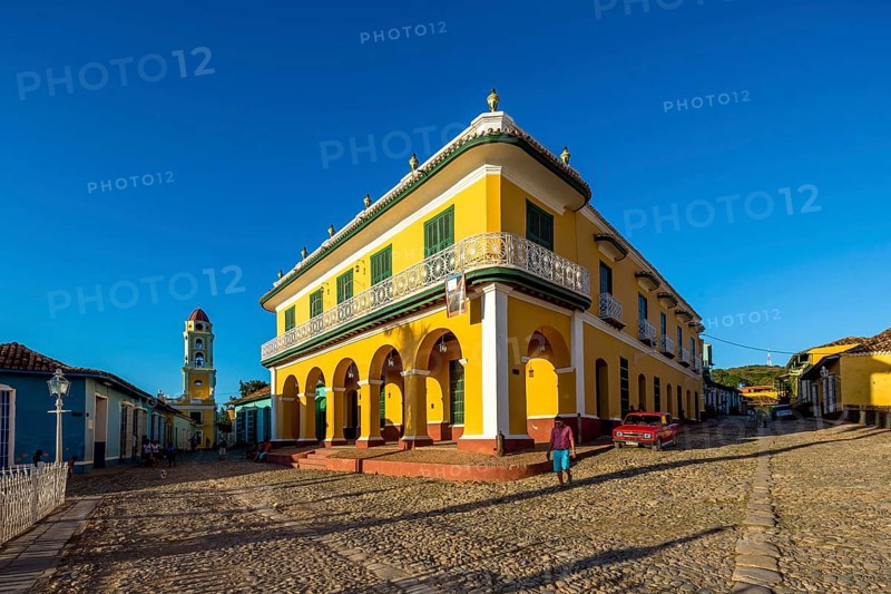 Centre of Trinidad Palacio Brunet, yellow palace with blue sky and the church Convento de San Francisco de Asis, Trinidad, Cuba, Sancti Spíritus, Sancti Spíritus