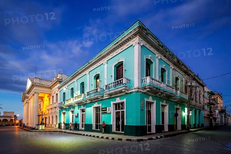 Turquoise residential building in the city centre of Santa Clara, Streetlife in the city centre of Santa Clara at the Parque de Santa Clara, Santa Clara, Cuba, Villa Clara