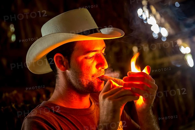 Tobacco farmer, tobacco farmer Luis Manne Alvares Rodrigues lights a Havana cigar, tobacco farm in the Vinales Valley, Viñales, Cuba, Pinar del Río, Viñales, Pinar del Río