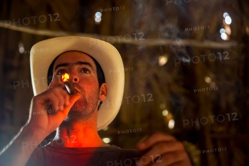 Tobacco farmer, tobacco farmer Luis Manne Alvares Rodrigues lights a Havana cigar, tobacco farm in the Vinales Valley, Viñales, Cuba, Pinar del Río, Viñales, Pinar del Río