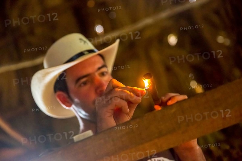Tobacco farmer, tobacco farmer Luis Manne Alvares Rodrigues lights a Havana cigar, tobacco farm in the Vinales Valley, Viñales, Cuba, Pinar del Río, Viñales, Pinar del Río
