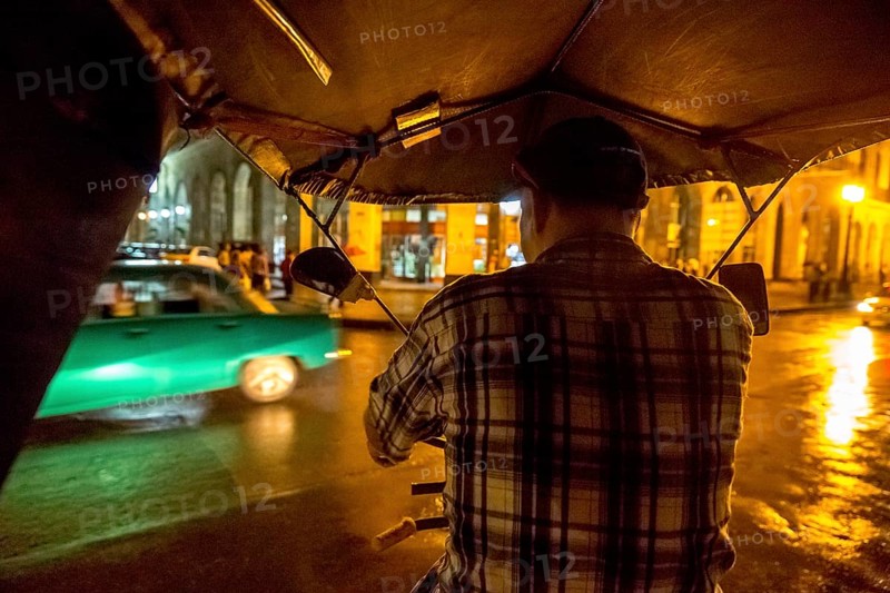 Rickshaw driver on a night ride through Havana, Havana, La Habana, Cuba, Cuba, Central America