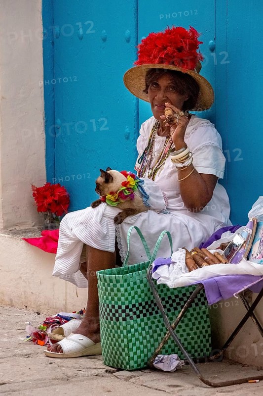 Old Cuban woman smokes a Cuban cigar on the street and posts with her cat for the tourists, La Habana, Cuba, Caribbean, Central America, Cuba, Europe, aerial photo, birds-eyes view, aerial photography, aerial photography, overview, bird's eye view
