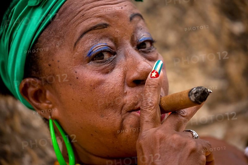 Old Cuban woman with green hair bow smokes a Havana cigar, Cuban woman with cigar and lacquered fingernails with the Cuban flag, Cuban flag, nail polish, La Habana, Cuba, Caribbean, Central America, Cuba, Europe, aerial view, birds-eyes view, aerial photography, aerial photography, overview, bird's eye view
