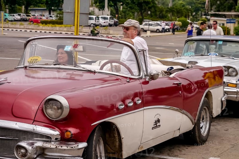 Tourists in a red convertible, red vintage convertible in the street scene, old American road cruisers on the streets of Havana, taxi, Havana, Cuba, Europe, aerial view, birds-eyes view, aerial photography, aerial photography, overview, bird's eye view