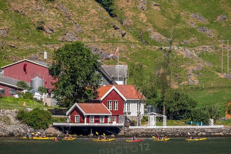 Tourists in yellow kayaks on fjord, river, Gudvangen, stone wall, mountain landscape, red wooden houses, Bakka, Sogn og Fjordane, Norway, Scandinavia, Europe, NOR, travel, tourism, destination, sightseeing, sea voyage, Hurtigruten, Hurtigruten trip, tourism, Norwegian, Scandinavian, tourist, cruise, adventure trip, mountain huts, houses, trees, meadows, rocks, mountains
