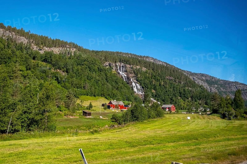 Red mountain huts, meadows, trees, waterfall, mountains, blue sky, Skulestadmo, Hordaland, Norway, Scandinavia, Europe, NOR, travel, tourism, destination, sightseeing, sea voyage, Hurtigruten, Hurtigruten trip, tourism, Norwegian, Scandinavian, tourist, cruise, adventure trip, landscape, forest, forestry, agriculture, water, valley, valley