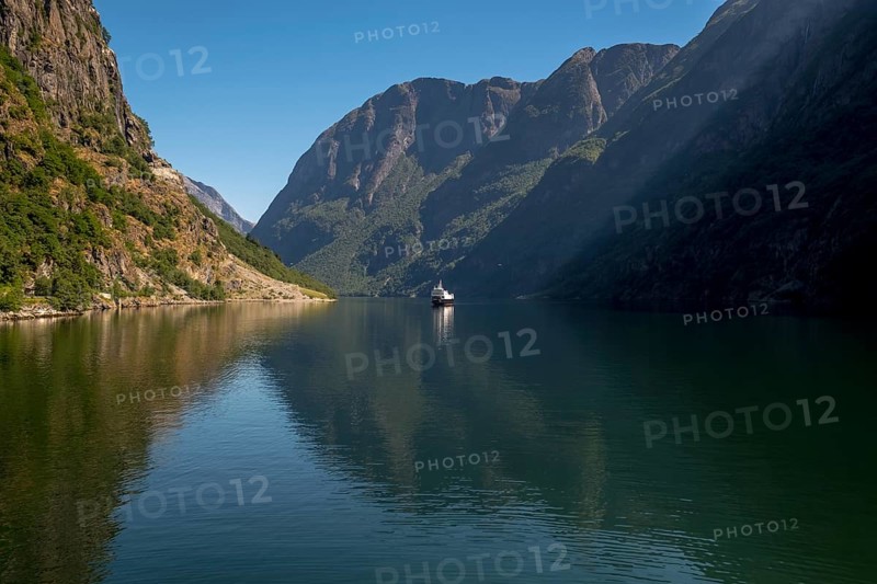Excursion ship on a fjord, Flåm, Gudvangen, rock walls, trees, blue sky, Sogn og Fjordane, Norway, Scandinavia, Europe, NOR, travel, tourism, destination, sightseeing, sea voyage, Hurtigruten, Hurtigruten trip, tourism, Norwegian, Scandinavian, tourist, cruise, adventure trip, mountains, tourist trip, shipping, river, stones, tourist ship, water, waters