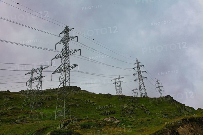 Electricity pylons on an overgrown hill under a cloudy sky, embedded in a natural landscape, power line, mountains, energy, Oberwald, Canton Valais, Switzerland