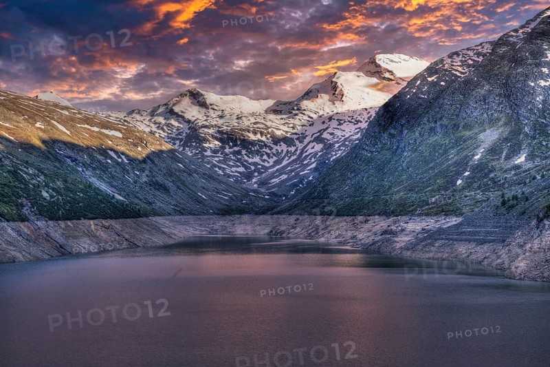 Snowy mountain peaks and a lake at sunset with pink and purple sky, Mattmark reservoir, Saas Almagell, Saas Grund, Canton Valais, Switzerland